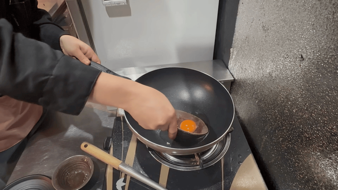 卵をフライパンに入れて目玉焼きを作る